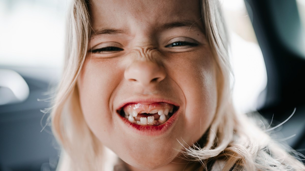 ett barn visar tänder i kameran